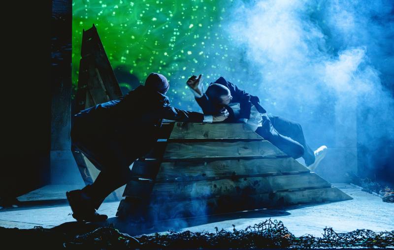 Two actors on stage surrounded by stage smoke